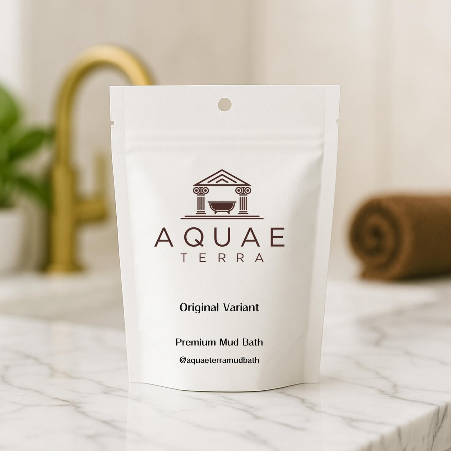 Aquae Terra premium at home mud bath packaging on a marble surface with a blurred bathroom background