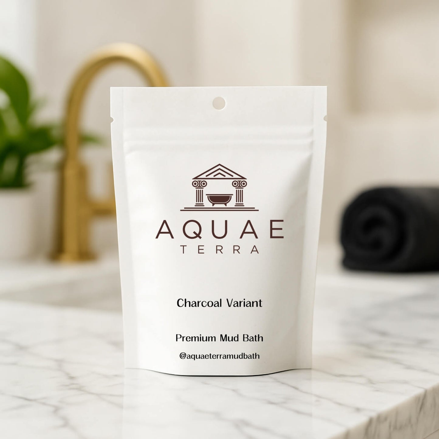 White packaging of Aquae Terra at home mud bath on a marble surface with a blurred bathroom background
