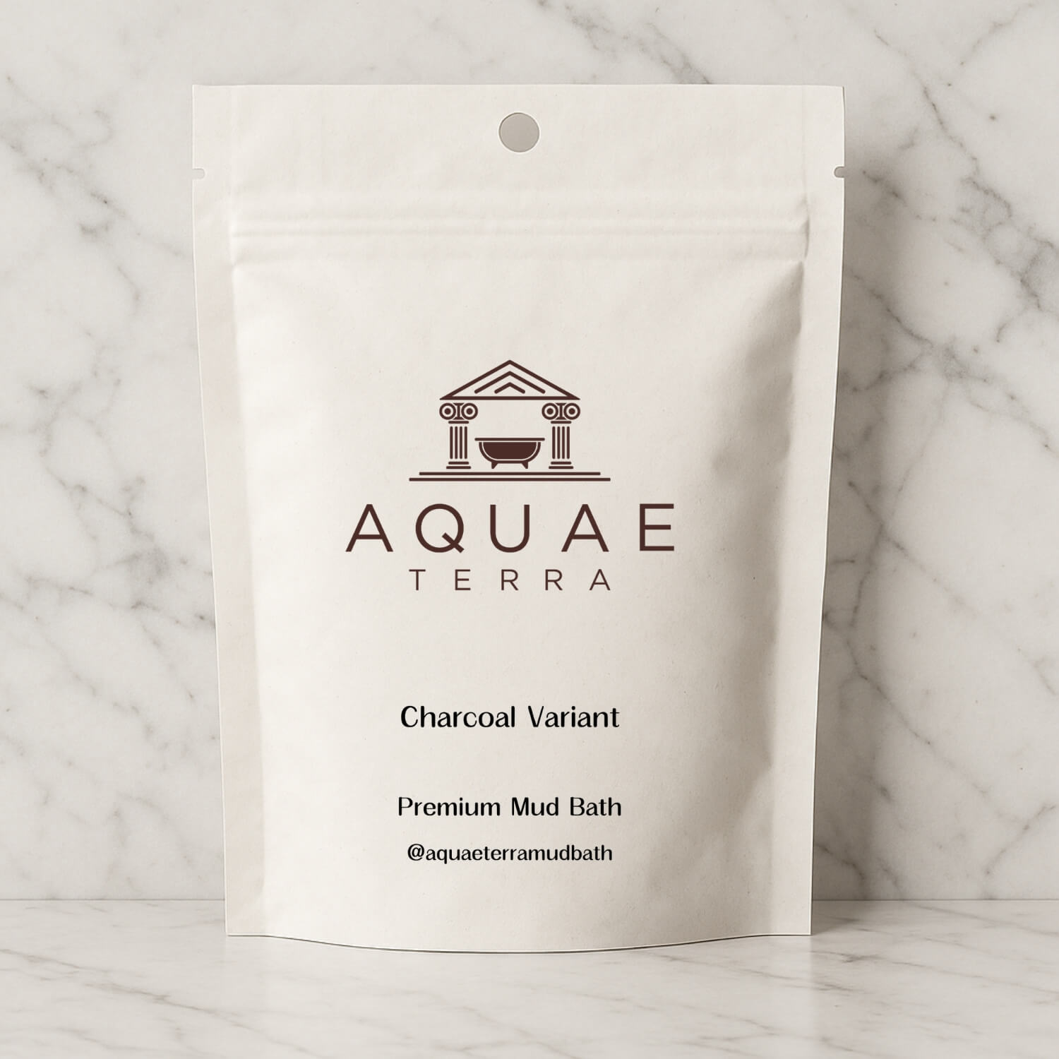 Aquae Terra at home charcoal mud bath package on a marble background